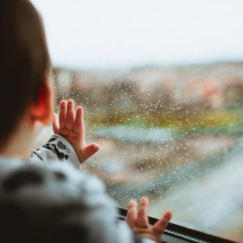 baby looking out a rainy window