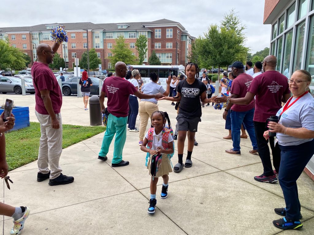Volunteers from Greater Mount Sinai Baptist Church and Bank of America join Renaissance West STEAM Academy staff in welcoming students on the first day of school Monday.