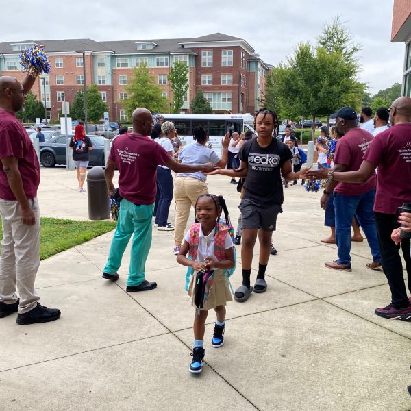 Volunteers from Greater Mount Sinai Baptist Church and Bank of America join Renaissance West STEAM Academy staff in welcoming students on the first day of school Monday.